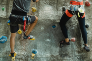 Strong athlete couple training on rocky climbing wall