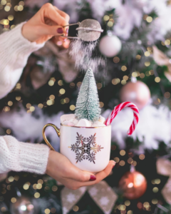 A Person Dusting a Hot Cocoa with Powdered Sugar
