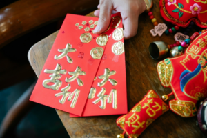 Woman with Chinese red envelope and decor for New Year
