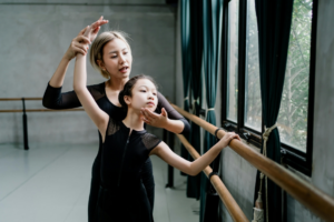 Asian ballet instructor explaining technique to girl