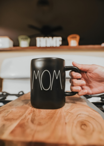 A Person Taking Black Mug With Word Mom