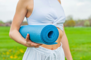 a woman is holding a yoga mat