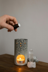 Person Putting Aroma Oil to a Candle