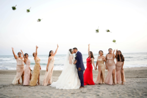 A Bride and Groom Kissing Between the Bridesmaids Throwing Their Bouquets