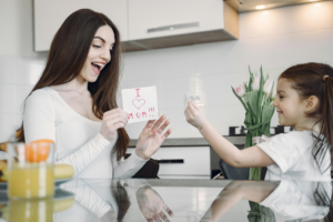 A Girl Showing Finger Heart Sign to Her Mom