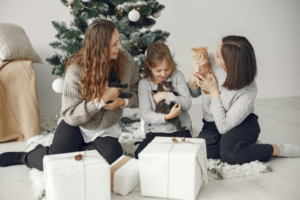 Mother with Children with Kittens near Christmas Tree
