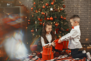 A Boy in White Long Sleeves Giving Gift to Her Sister
