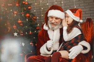 Little Girl Whispering into Santa Clauses Ear
