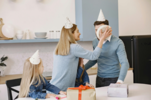 Woman Putting Birthday Cake on Man Face
