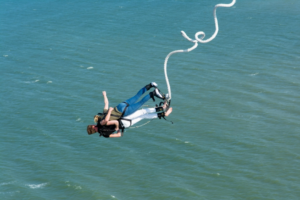 Two People Bungee Jumping over the Sea