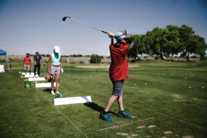 Person Swinging Golf Club on Field