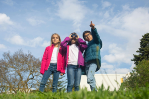 A Girl Holding a Binoculars and a Boy Pointing Where to Look At