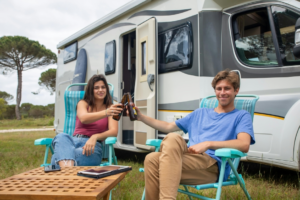 Couple Clinking Bottles of Beer on Camping