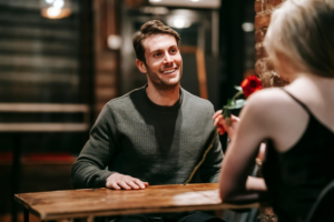 Happy couple sitting at table in cafe during date