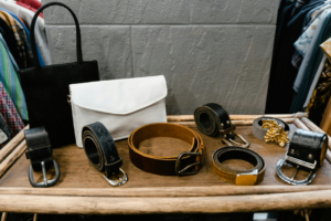 Assorted Black Leather Belts on Brown Wood Table