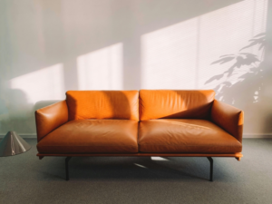 Two Seated Orange Leather Sofa Beside Wall