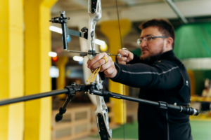 a man is targeting something with a hunting tool 