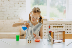 A Girl Holding a Flask with Colored Liquid
