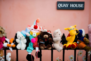 Colorful Stuffed Toys on Railing in Appledore