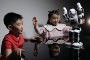 Kids Looking at White Toy Robot on the Table
