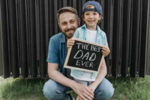 A Man Hugging His Son Holding a Blackboard