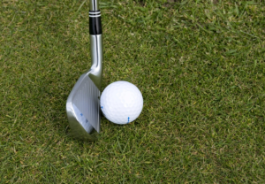 a golf stick and a white color golf ball