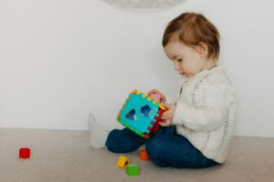 A baby playing with blocks on the floor
