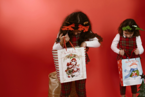 Girls Looking at the Paper Bags they are Holding
