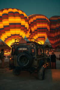 People Standing Near Colorful Hot-Air Balloons during Night Time