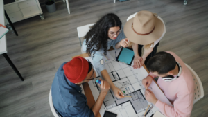 Four people sitting around a table with a laptop