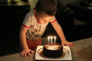 Boy in Crew Neck T-shirt Looking at the Chocolate Cake with Candles