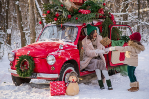 Mother and Daughter with Red Car with Christmas Tree on top
