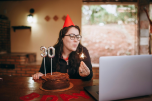 Woman Celebrating Her 30th Birthday Alone with Cake in Front of Laptop
