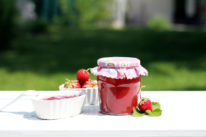 A Glass Jar with Strawberry Jam on the Table
