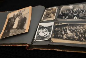 An open photo album displaying several black and white vintage photographs, including a wedding portrait, group gatherings-evoking a sense of nostalgia and family history.