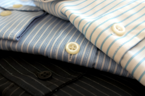 A set of neatly folded, high-quality striped dress shirts, showcasing elegance and sophistication — perfect expensive gifts for men who appreciate fine tailoring.