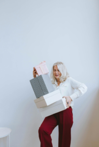 a  older woman is holding some gift boxes