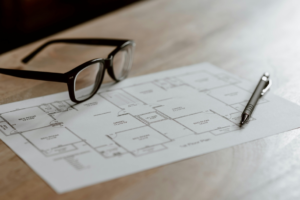 a black sunglass and a pen on the table