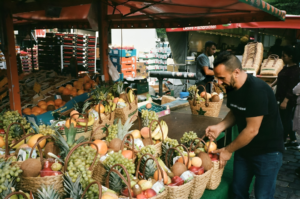 a man is buying different types of fruits from fruit baskets