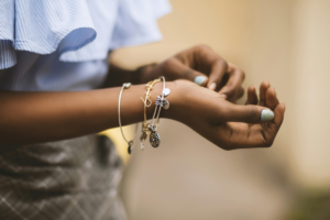 A woman is wearing three bracelets in her one hand