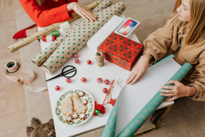 Woman in Brown Jacket Holding Green and White Wrapping Paper
