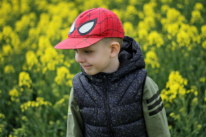 A boy wearing Spiderman themed cap