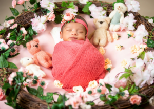 A Newborn Baby Girl Wrapped in a Pink Blanket Lying in a Basket
