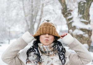 A Person Under the Snow Wearing a Brown Knit Cap And Knitted scarve