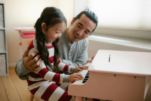 Father with Daughter Playing Toy Piano
