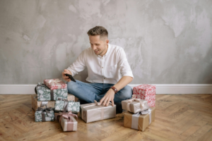 Man Surrounded by Gifts Holding a Cellphone