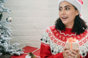 Amazed ethnic woman getting Christmas present